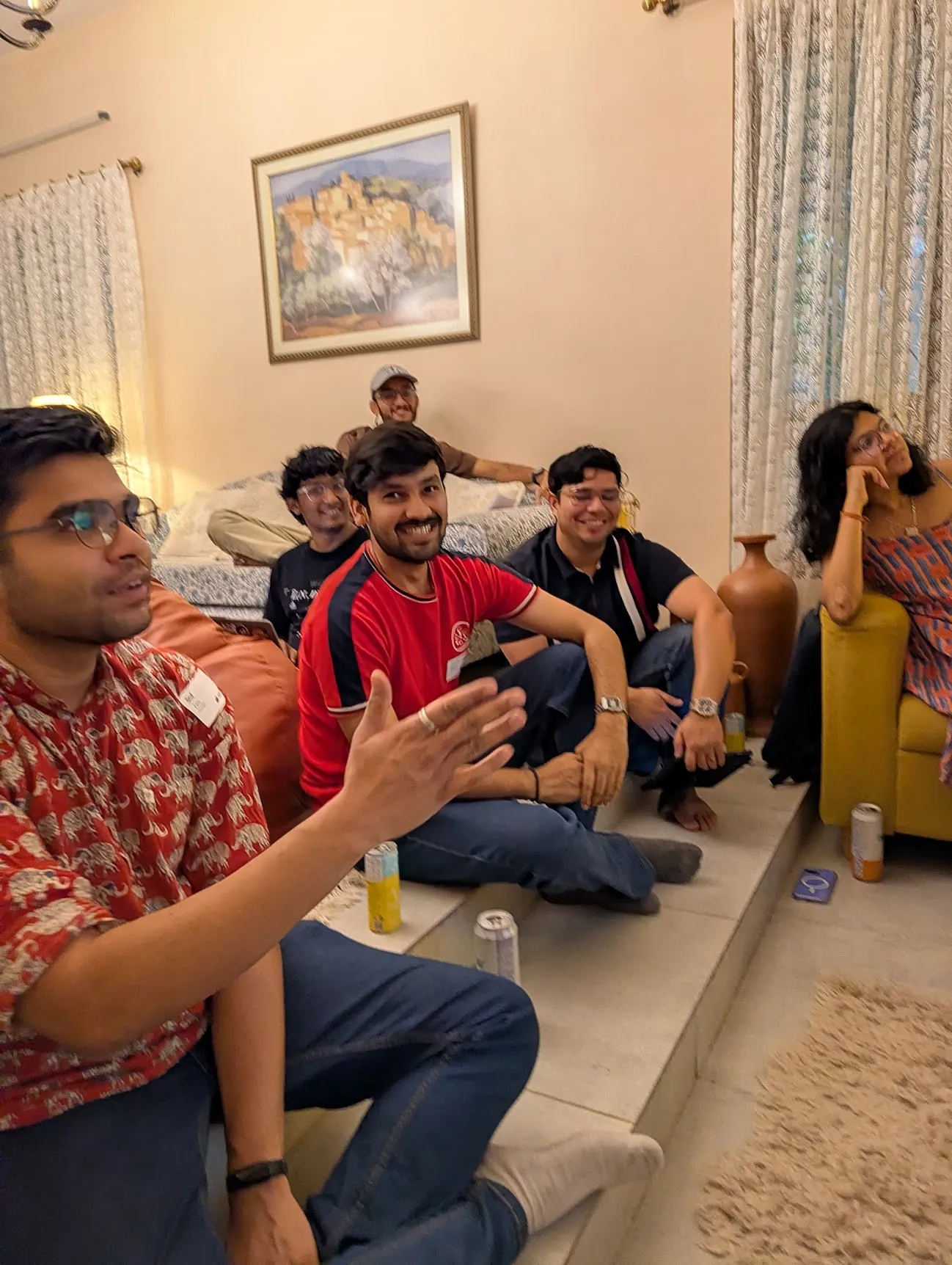 People sitting on the floor and a sofa, mid-conversation and laughing.
