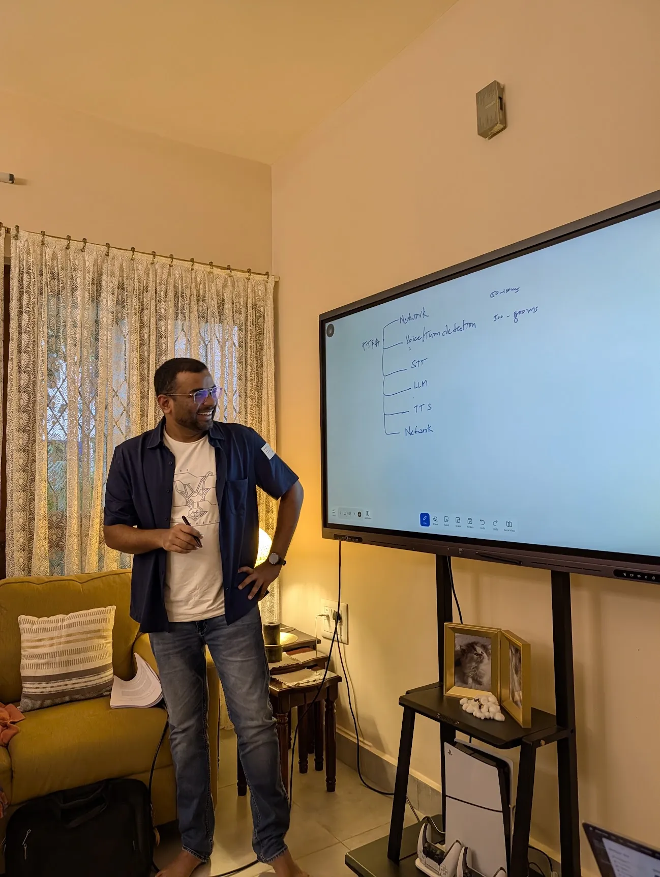 A participant standing at a screen that shows time to first audio split into network, turn detection, speech to text, LLM, text to speech and network.